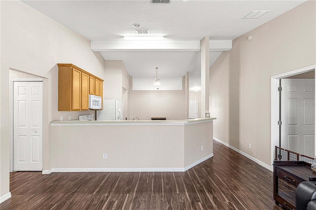 kitchen with a textured ceiling, dark wood-type flooring, and white appliances