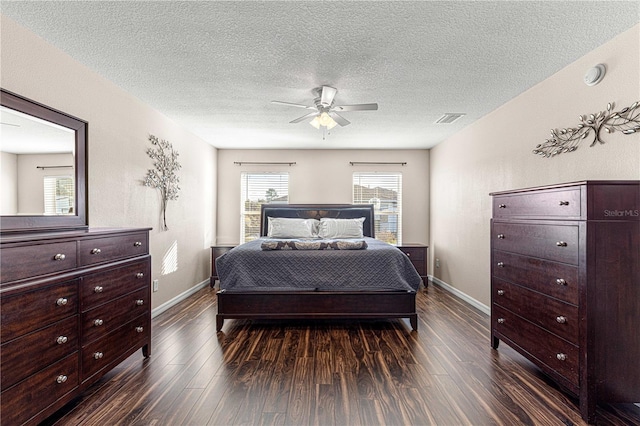 bedroom featuring a textured ceiling, ceiling fan, and dark wood-type flooring