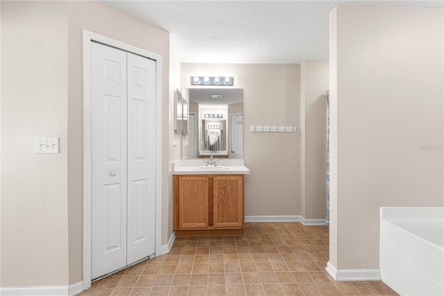 bathroom featuring a textured ceiling, vanity, and a bathtub