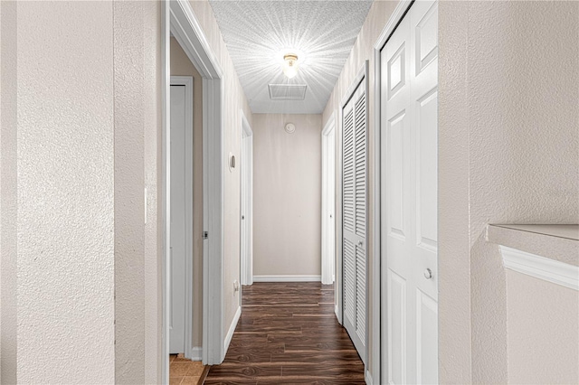 hall with dark hardwood / wood-style flooring and a textured ceiling