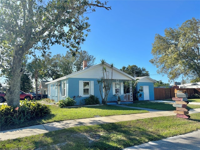 ranch-style home with a front lawn and covered porch