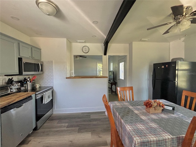 kitchen featuring backsplash, ceiling fan, stainless steel appliances, and dark wood-type flooring