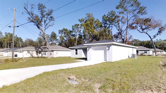 view of side of property with a garage, a lawn, and central air condition unit