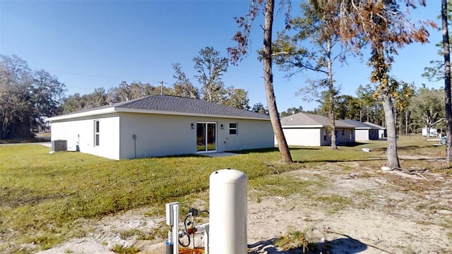 rear view of house featuring cooling unit and a yard