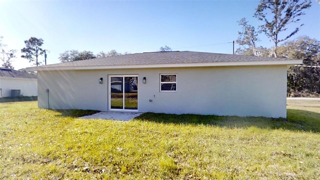 rear view of house with a yard and central AC