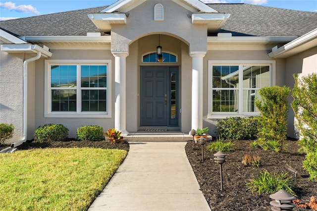 entrance to property with a lawn