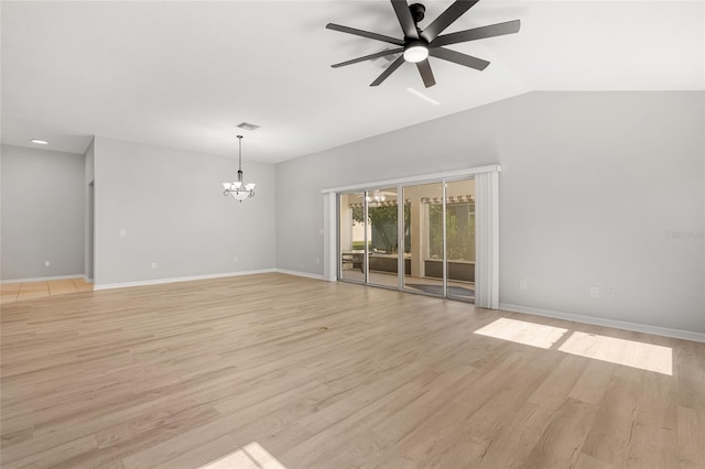 spare room with ceiling fan with notable chandelier, light wood-type flooring, and vaulted ceiling