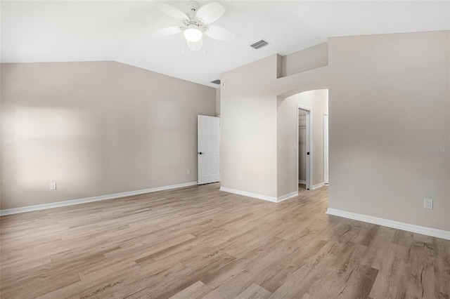 empty room with ceiling fan, vaulted ceiling, and light wood-type flooring