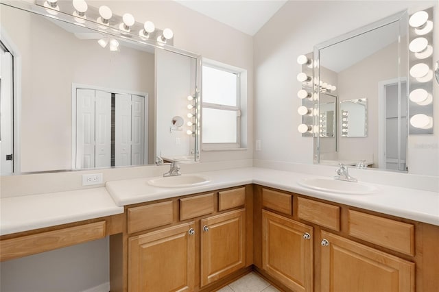 bathroom with tile patterned floors, vanity, and lofted ceiling