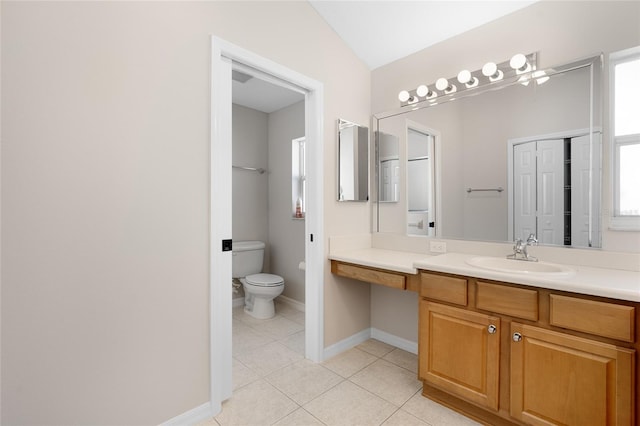 bathroom with tile patterned floors, vanity, vaulted ceiling, and toilet