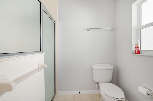 bathroom featuring tile patterned flooring, toilet, and walk in shower