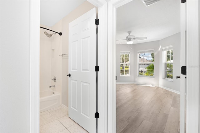 bathroom with ceiling fan, wood-type flooring, and tiled shower / bath