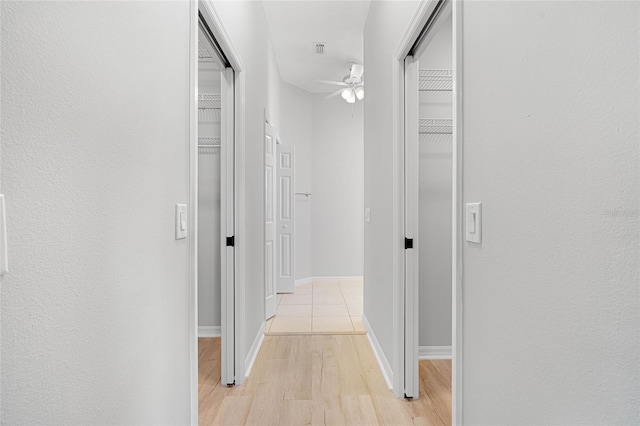 corridor with light hardwood / wood-style floors