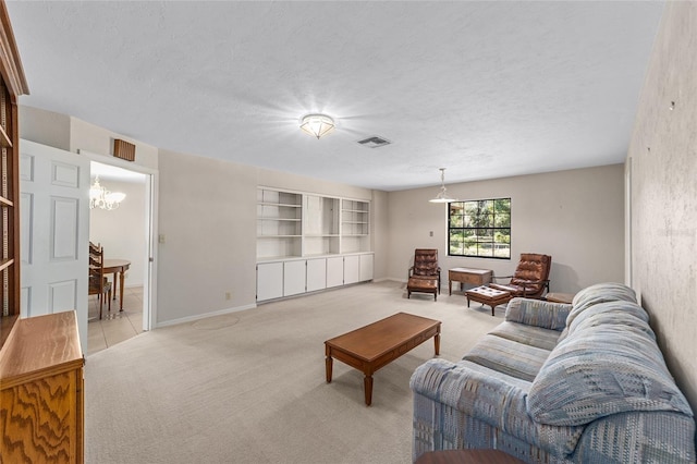 carpeted living room with a textured ceiling and a chandelier