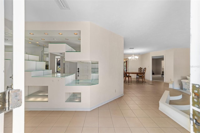 corridor featuring a notable chandelier and light tile patterned flooring