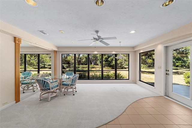 unfurnished sunroom with ceiling fan