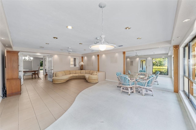 dining area featuring light tile patterned floors and ceiling fan with notable chandelier