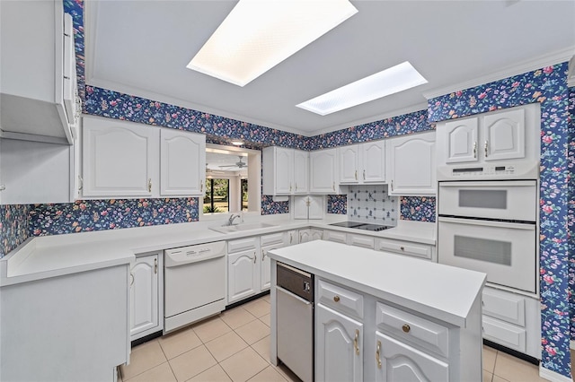 kitchen with white cabinets, light tile patterned floors, white appliances, and sink