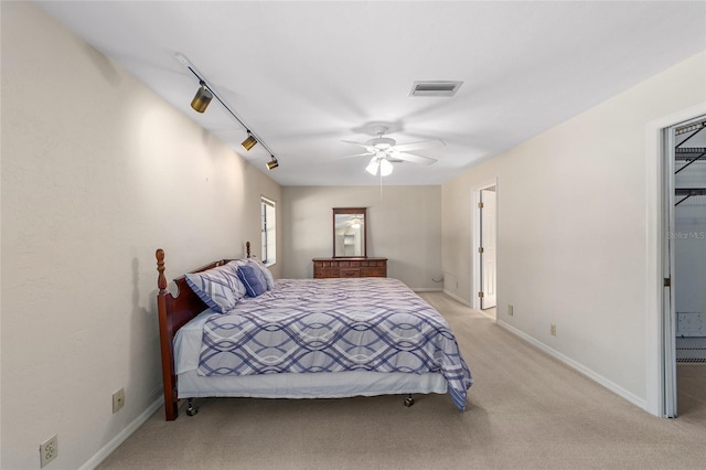 carpeted bedroom featuring connected bathroom, ceiling fan, and rail lighting