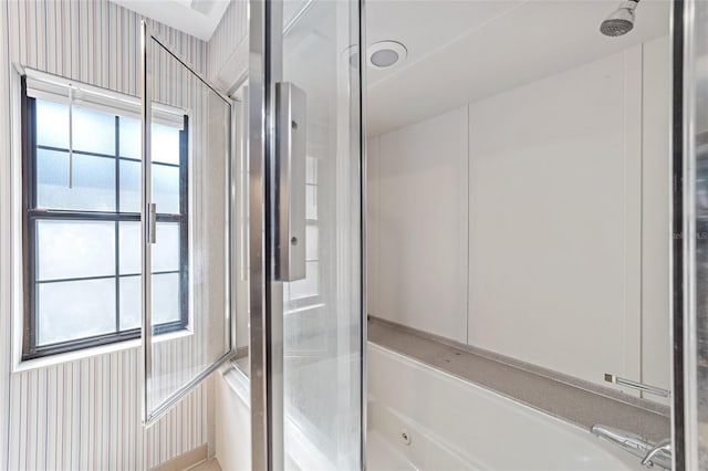 bathroom with plenty of natural light and shower / bath combination with glass door