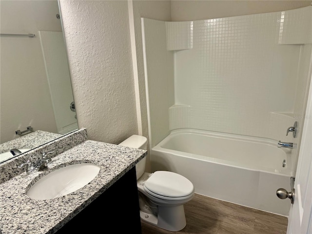 full bathroom featuring hardwood / wood-style floors, vanity, toilet, and tub / shower combination