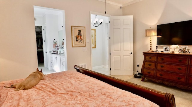 bedroom featuring light carpet, ensuite bath, crown molding, and a notable chandelier