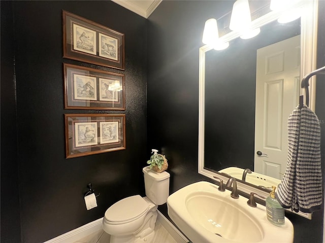 bathroom featuring sink, ornamental molding, and toilet