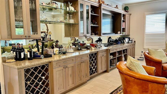 bar with light stone counters, ornamental molding, and wine cooler