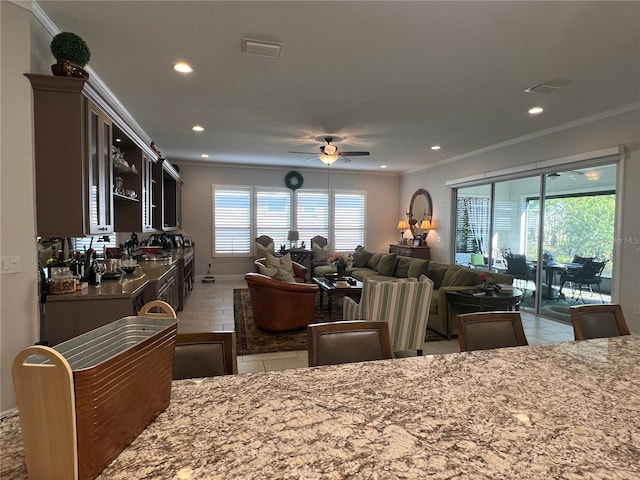 dining room featuring tile patterned floors, ceiling fan, and crown molding