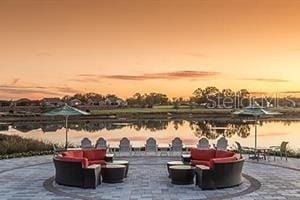 patio terrace at dusk featuring a water view