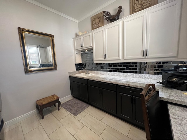 kitchen with sink, light tile patterned floors, backsplash, white cabinets, and ornamental molding