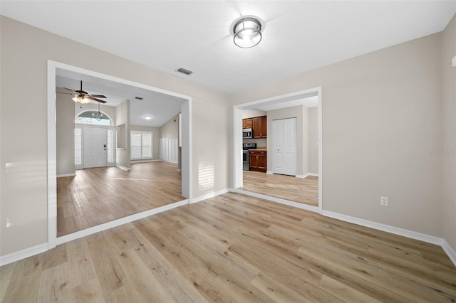 unfurnished living room with light wood-type flooring and ceiling fan