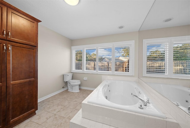 bathroom featuring tile patterned floors, toilet, and tiled tub