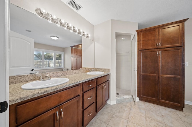 bathroom featuring tile patterned floors, vanity, and walk in shower