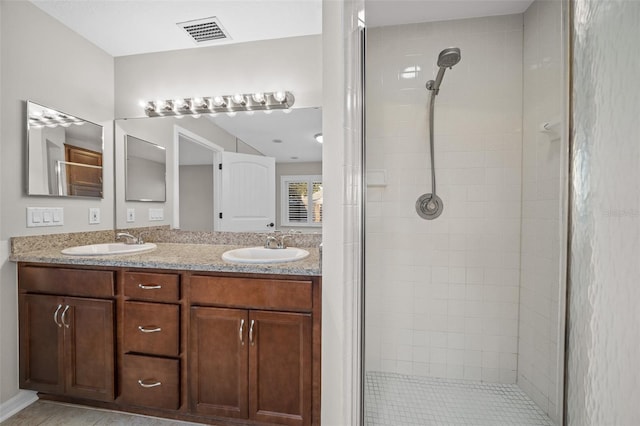 bathroom featuring a tile shower and vanity