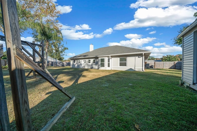 rear view of property with a lawn