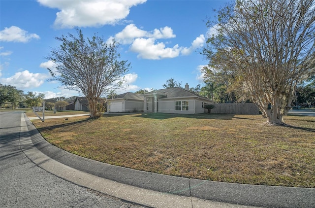 single story home featuring a front lawn and a garage