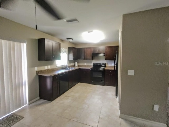 kitchen featuring dark brown cabinetry, sink, black electric range oven, and light tile patterned floors