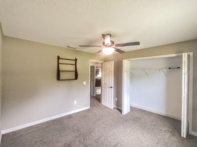 unfurnished bedroom with carpet flooring, ceiling fan, a textured ceiling, and a closet