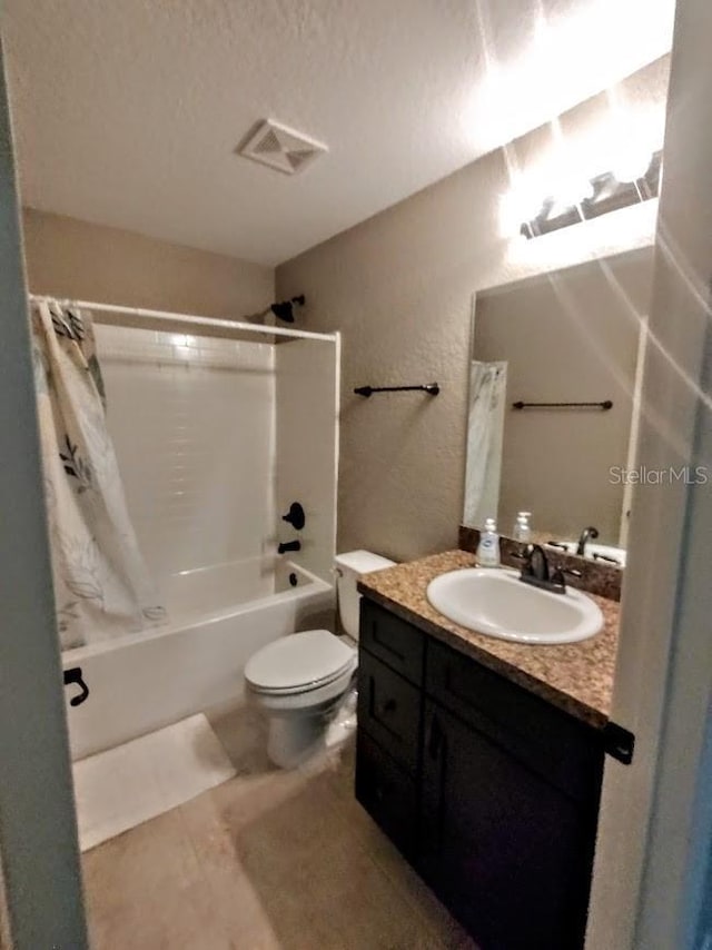 full bathroom with a textured ceiling, vanity, shower / tub combo with curtain, tile patterned flooring, and toilet