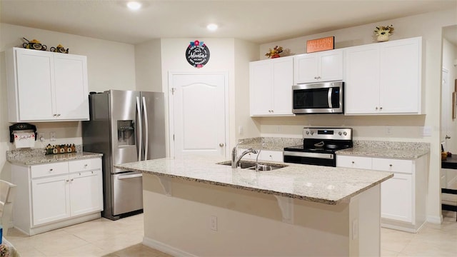 kitchen featuring sink, stainless steel appliances, an island with sink, and white cabinets