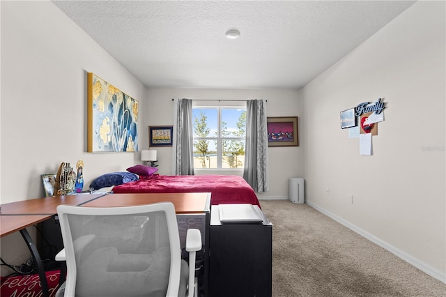 bedroom featuring carpet, baseboards, and a textured ceiling