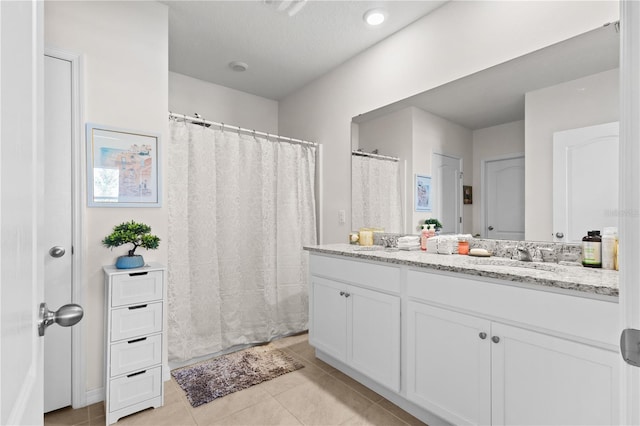 bathroom with double vanity, a sink, and tile patterned floors