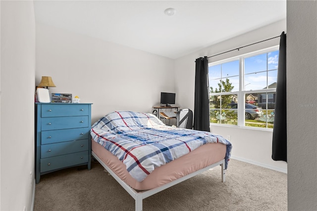 bedroom with light colored carpet and baseboards