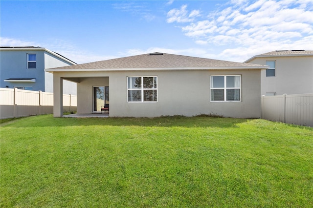 rear view of house featuring a patio, a lawn, a fenced backyard, and stucco siding