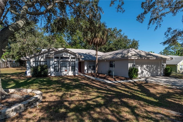 ranch-style house featuring a front lawn and a garage