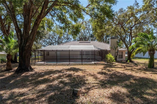 rear view of property featuring glass enclosure