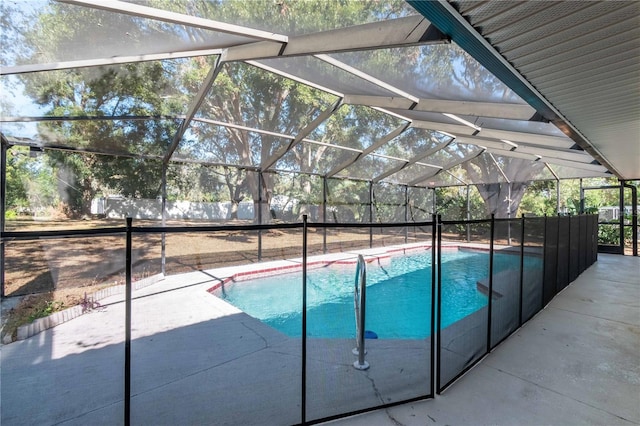 view of pool with glass enclosure and a patio area