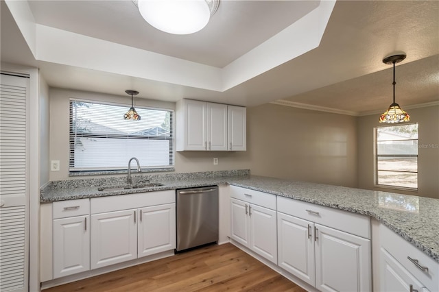 kitchen with white cabinetry, sink, light hardwood / wood-style flooring, stainless steel dishwasher, and decorative light fixtures