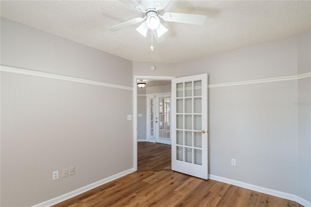 unfurnished room featuring hardwood / wood-style flooring, ceiling fan, a textured ceiling, and french doors